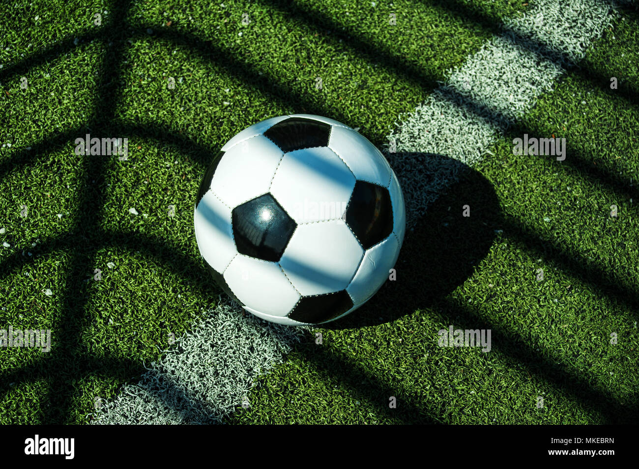 soccer ball classic black and white with shadows on the ground of an