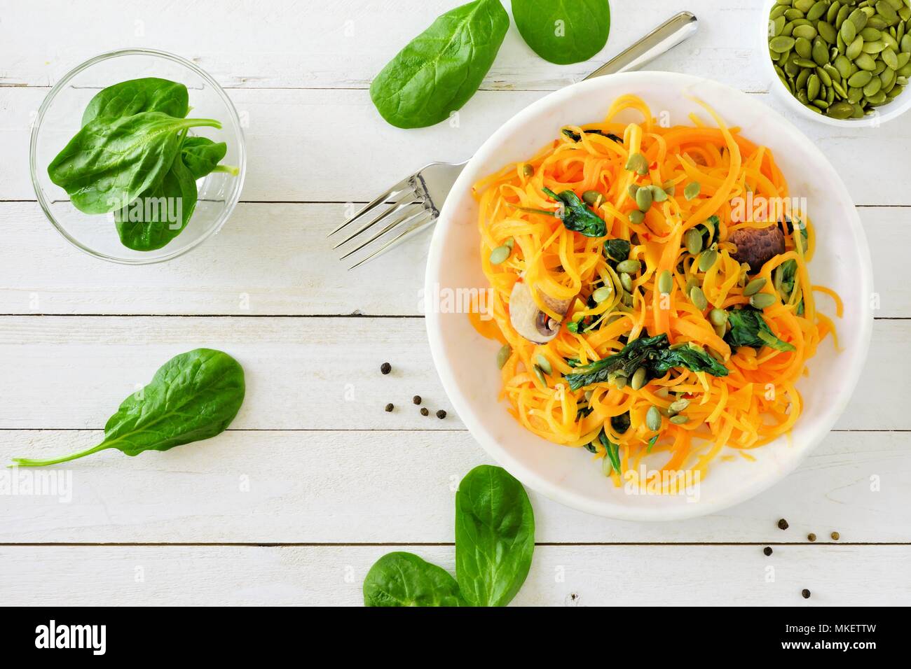 https://c8.alamy.com/comp/MKETTW/butternut-squash-spirilized-noodles-with-spinach-and-pumpkin-seeds-on-white-wood-background-healthy-eating-concept-top-view-table-scene-MKETTW.jpg