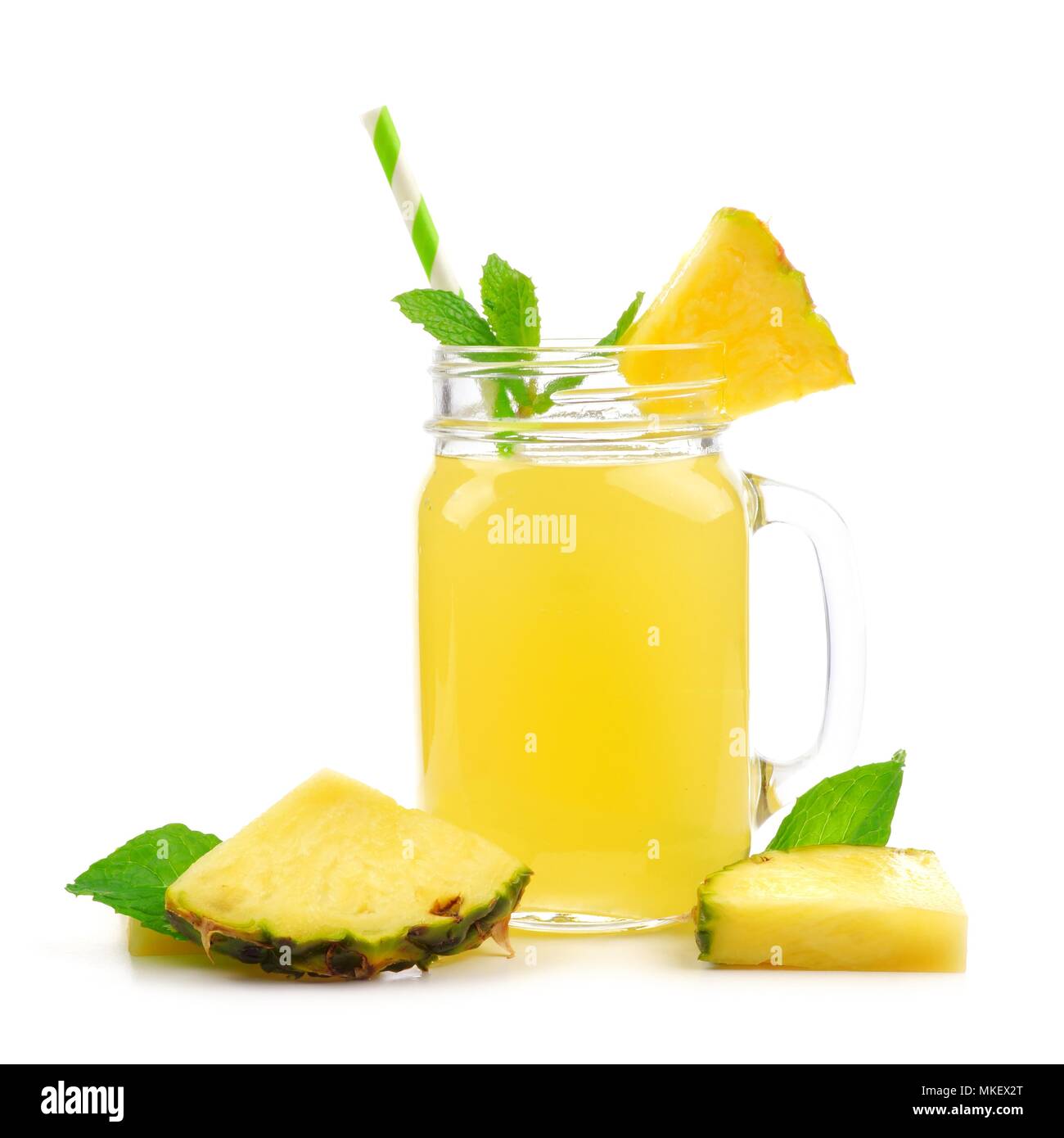 Pineapple juice in a mason jar glass with fruit, mint and straw isolated on a white background Stock Photo