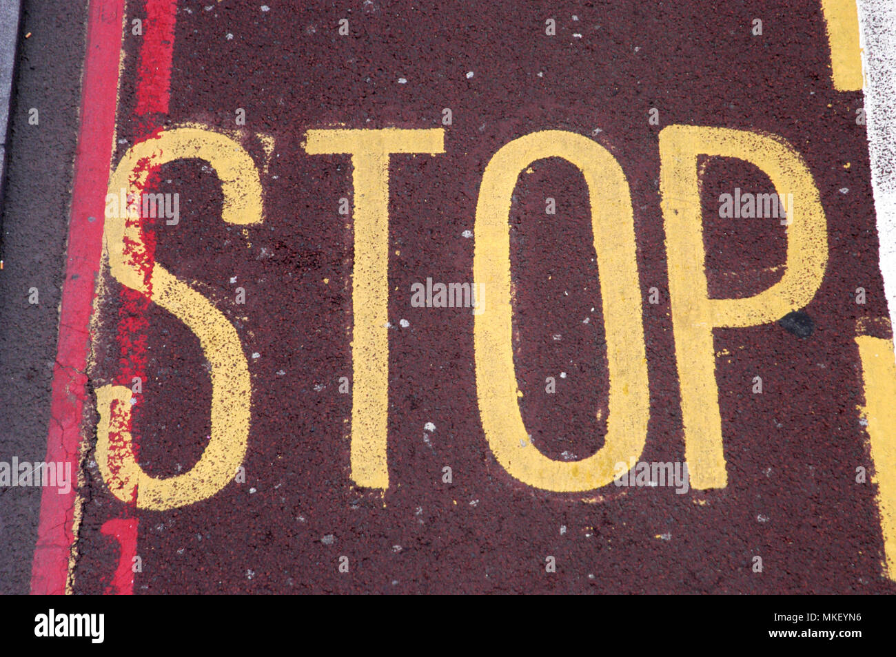 city centre traffic control zones stop sign in yellow with red lines on red tarmac Stock Photo