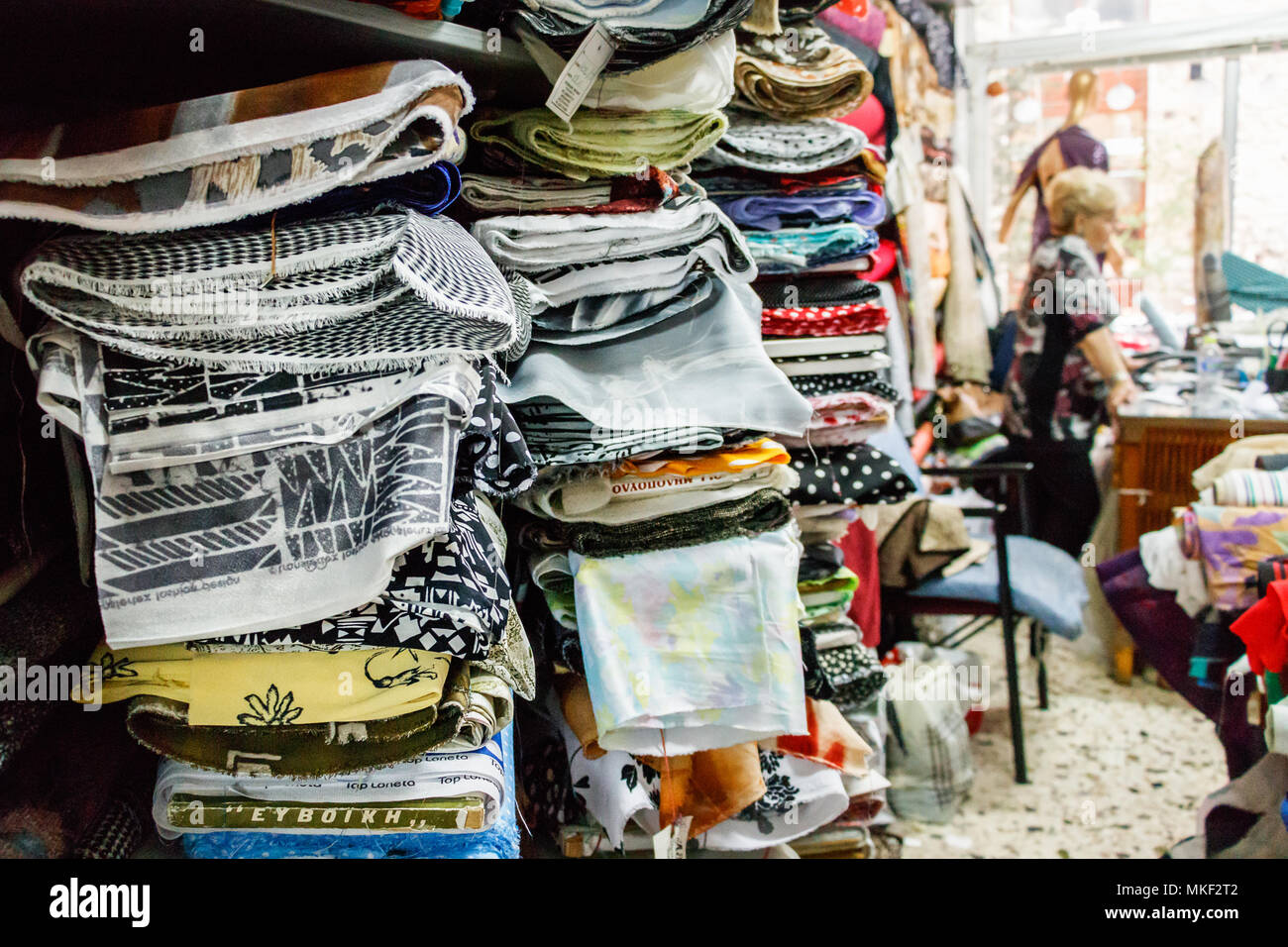 Larissa, Thessaly, Greece - May 4th, 2018: Fabric rolls stacked on the  walls of a Greek Store with the owner in the background in the Larissa City  dow Stock Photo - Alamy