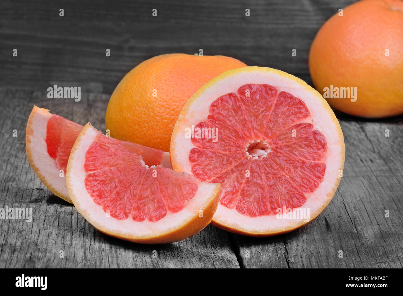 Fresh red grapefruit on gray rustic wooden table Stock Photo