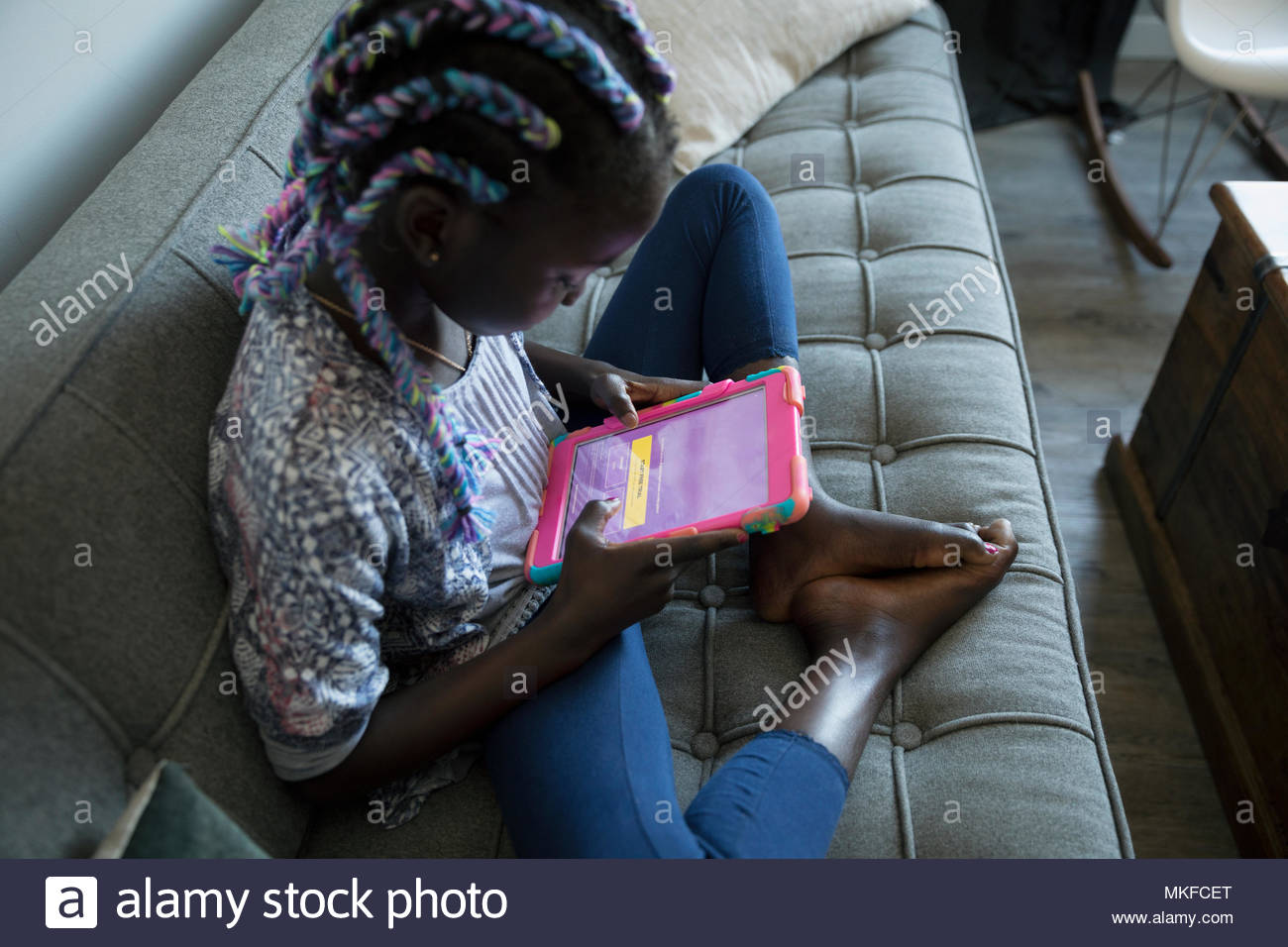 Girl sitting barefoot on sofa hi-res stock photography and images - Alamy
