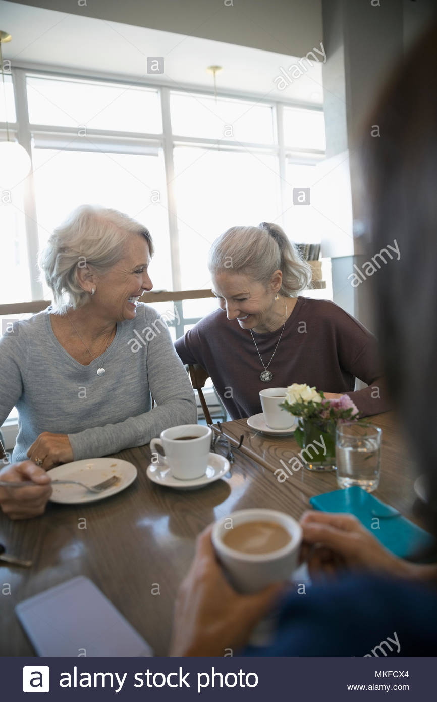 Laughing, active senior women drinking coffee in cafe Stock Photo