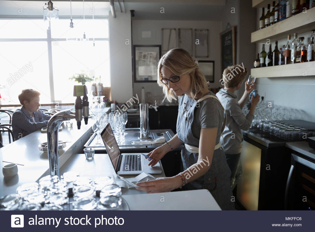Family business owner working at laptop in cafe Stock Photo