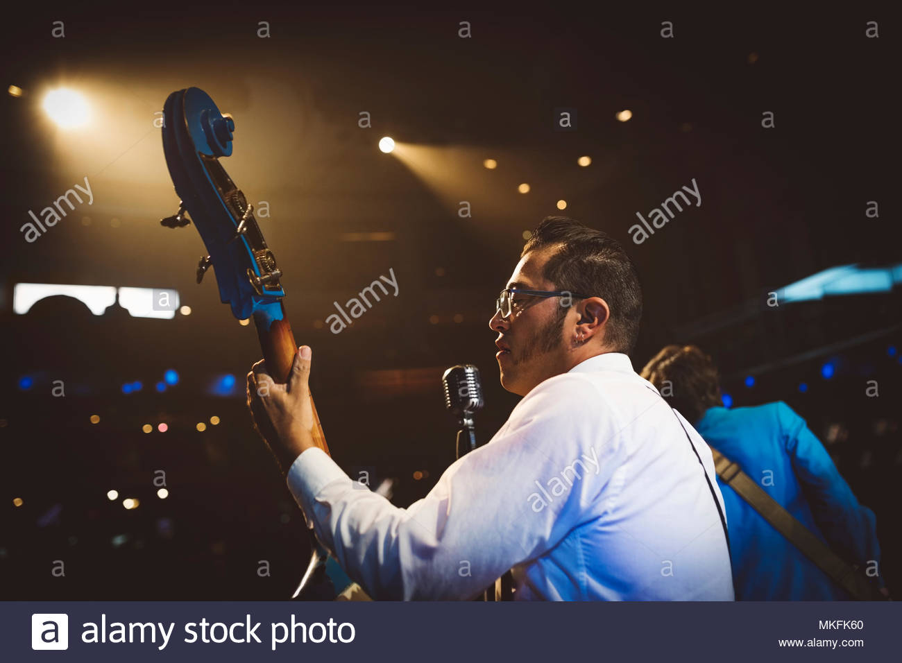 Rockabilly musician playing double bass on stage at music concert Stock Photo