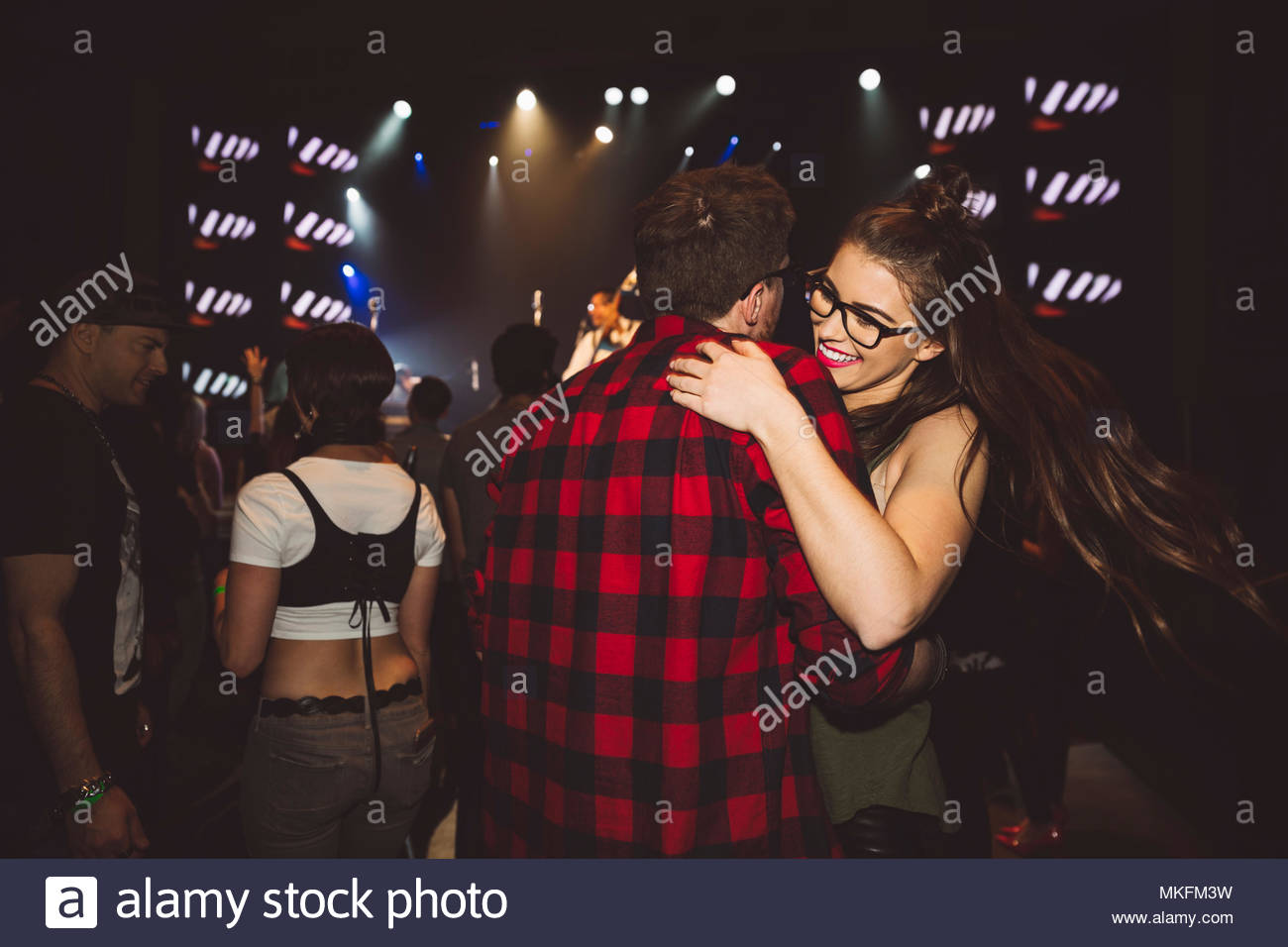 Young millennial couple dancing at music concert in nightclub Stock Photo
