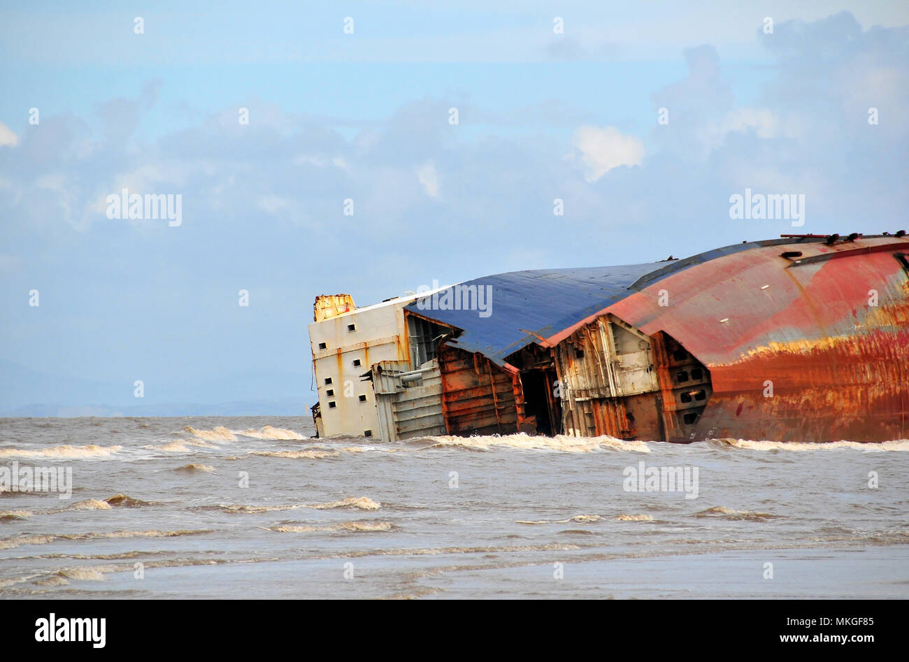 Sunny high sideview of Riverdance Ferry Wreck, on its side, bow plates dismantled, Anchorsholme, Cleveleys, north of Blackpool, Lancashire, UK Stock Photo