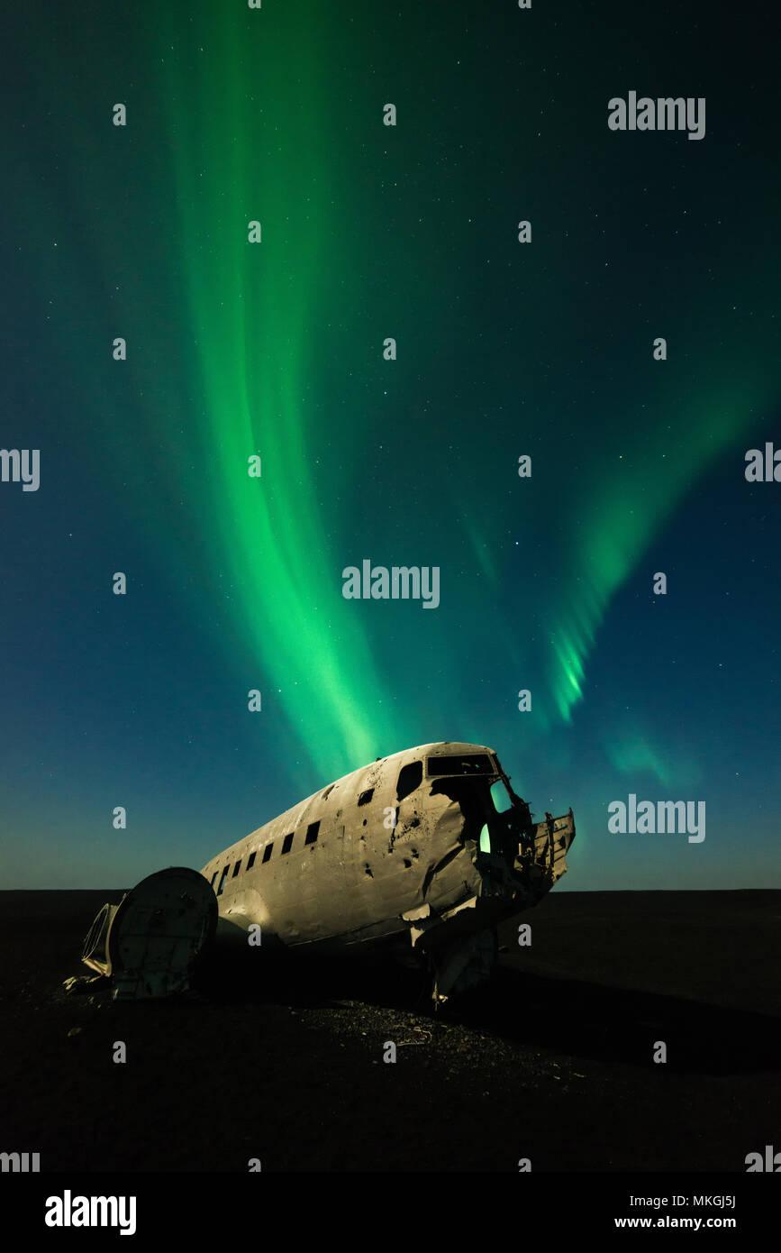 The wreckage of the crashed US Navy Douglas DC-3 aircraft under the green aurora borealis (northern lights) and lit by the moon, Iceland Stock Photo