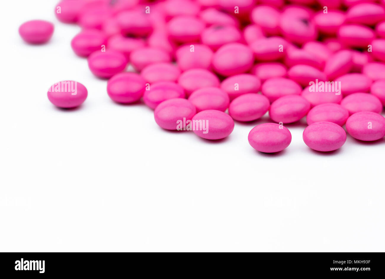 Closeup pile of pink round sugar coated tablets pills isolated on white background with copy space. Amitriptyline medicine for treatment anti-anxiety, Stock Photo