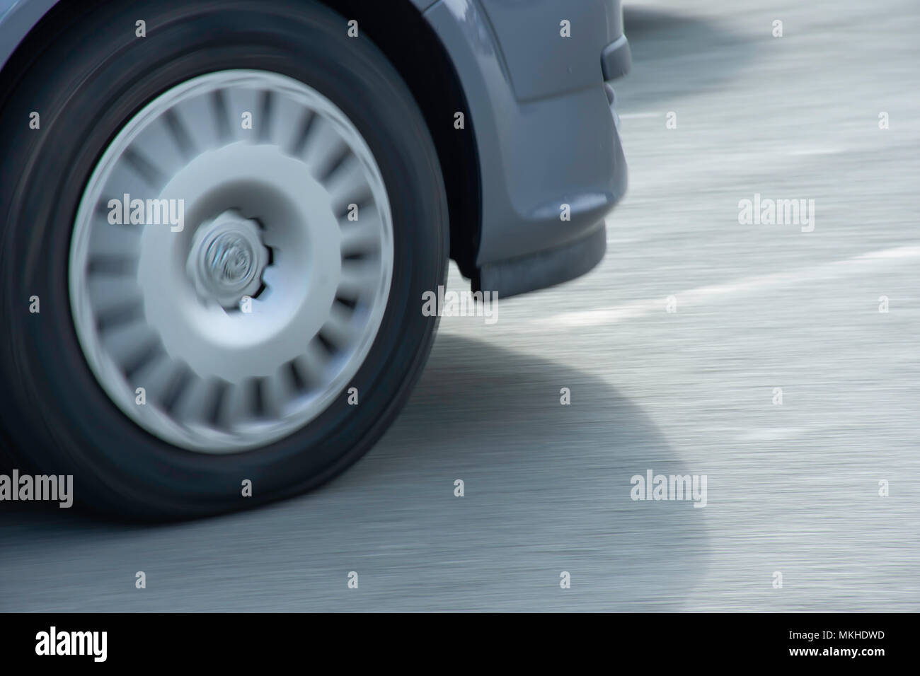 Spinning back wheel of car driving on uk road.Moto abstract, theme