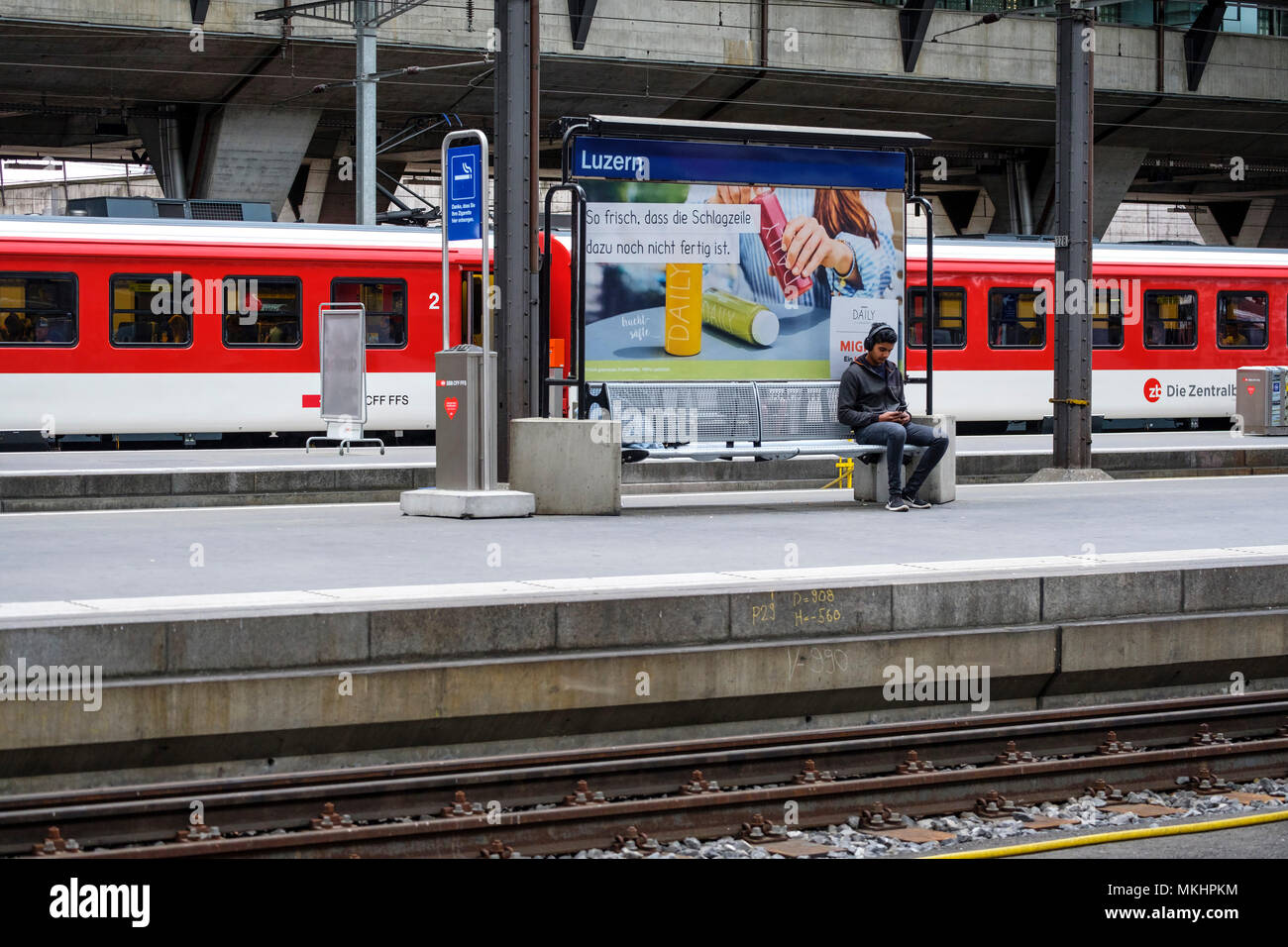 Man waiting for the train to arrive at the Lucerne Main Station, Lucerne, Switzerland, Europe Stock Photo