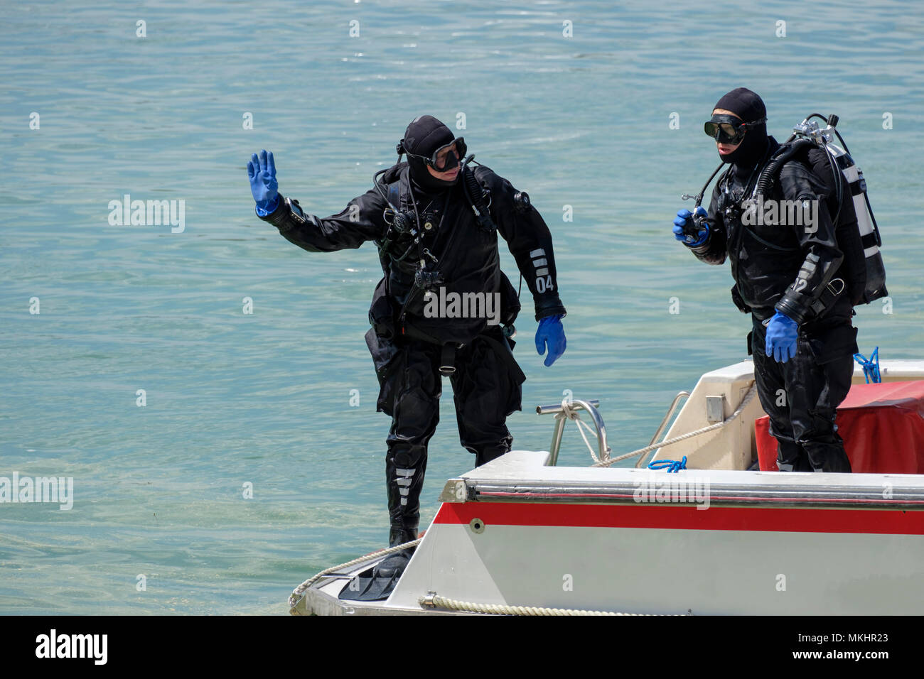 Two scuba divers in full diving gear on a boat Stock Photo