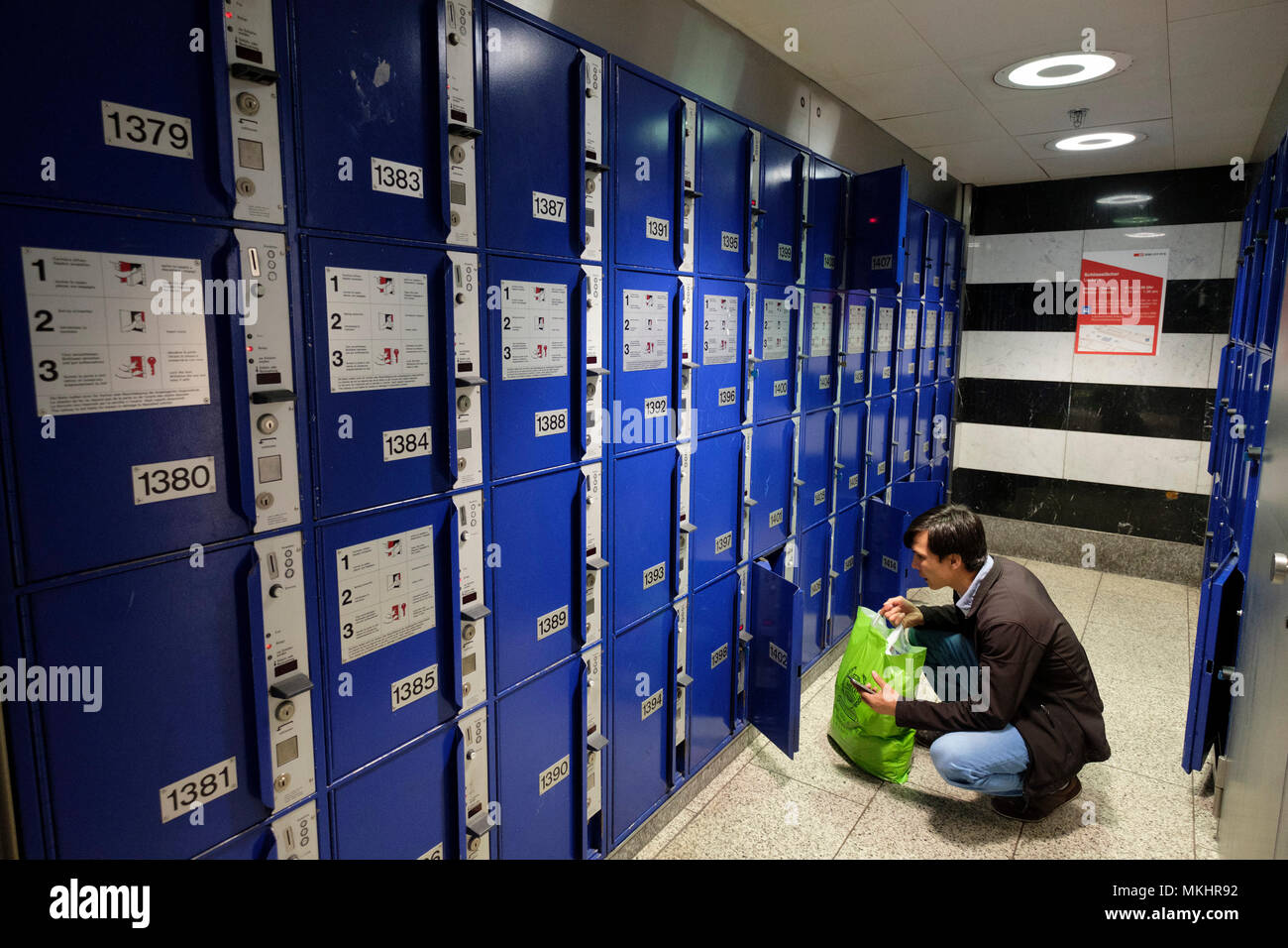 Man leaving a bag in luggage storage lockers at Zurich Main Station, Zürich, Switzerland, Europe Stock Photo