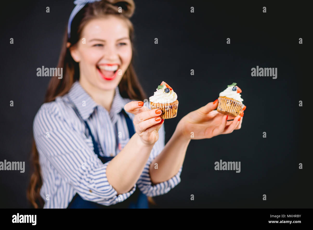 Beautiful pastry woman holding cupcake in hands and giving different emotions Stock Photo Alamy