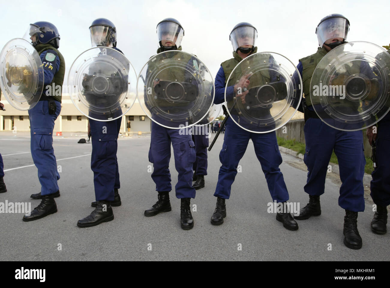 Riot police officers lined up with protective headgear and shields Stock Photo