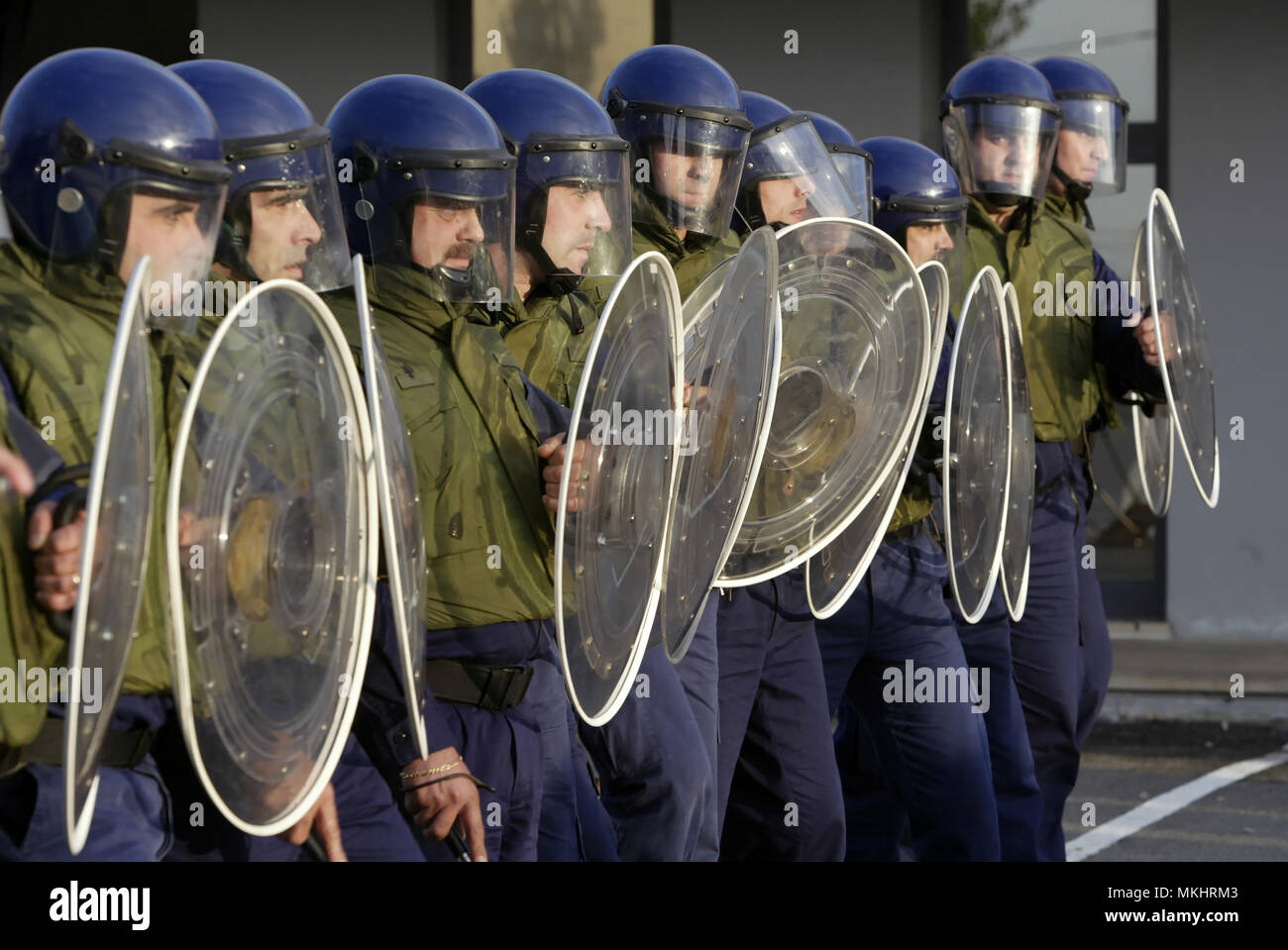 Riot police officers lined up with protective headgear and shields Stock Photo