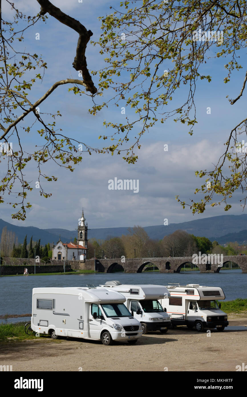 Three motorhomes parked next to the Lima river in Ponte de Lima