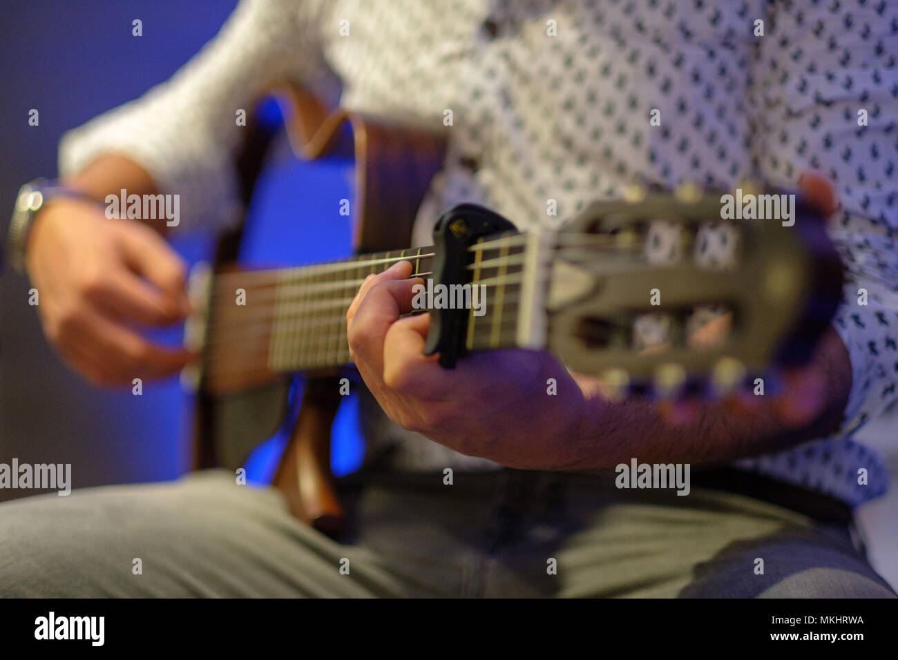 Selective focus photo of a man playing a bodiless guitar Stock Photo