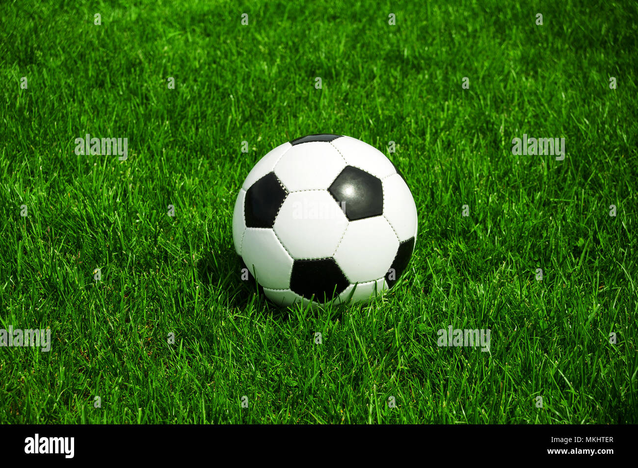 soccer ball black and white classic in the green grass alone with space Stock Photo