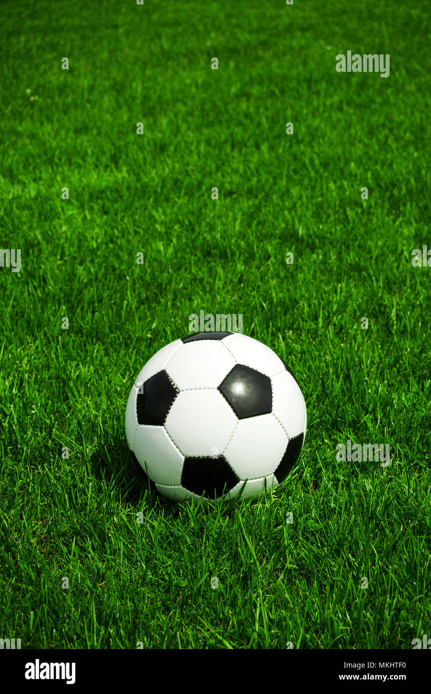 soccer ball black and white classic in the green grass alone with space Stock Photo
