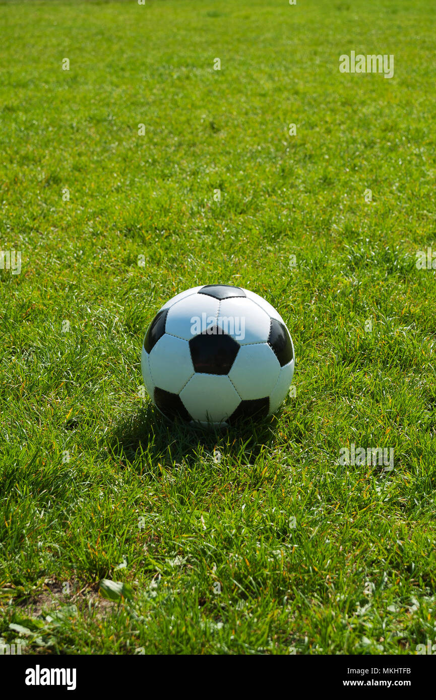 soccer ball black and white classic in the green grass alone with space Stock Photo