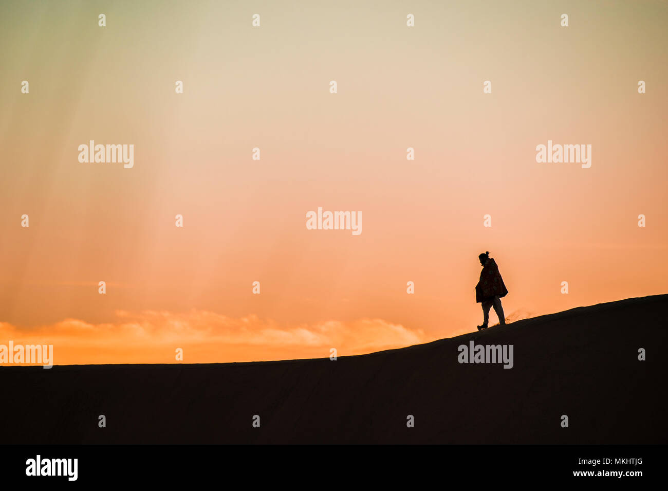 Man walk on a desert sand dunes at sunset in Rajasthan, India. Stock Photo