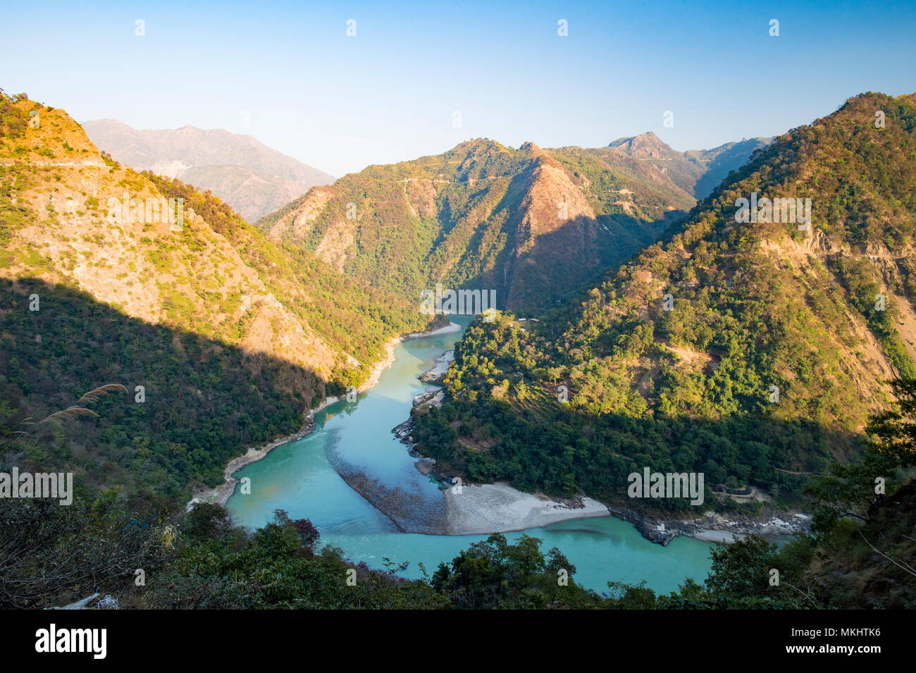 Wonderful green peaks of some mountains with the Ganges river flowing between them in Rishikesh, India Stock Photo