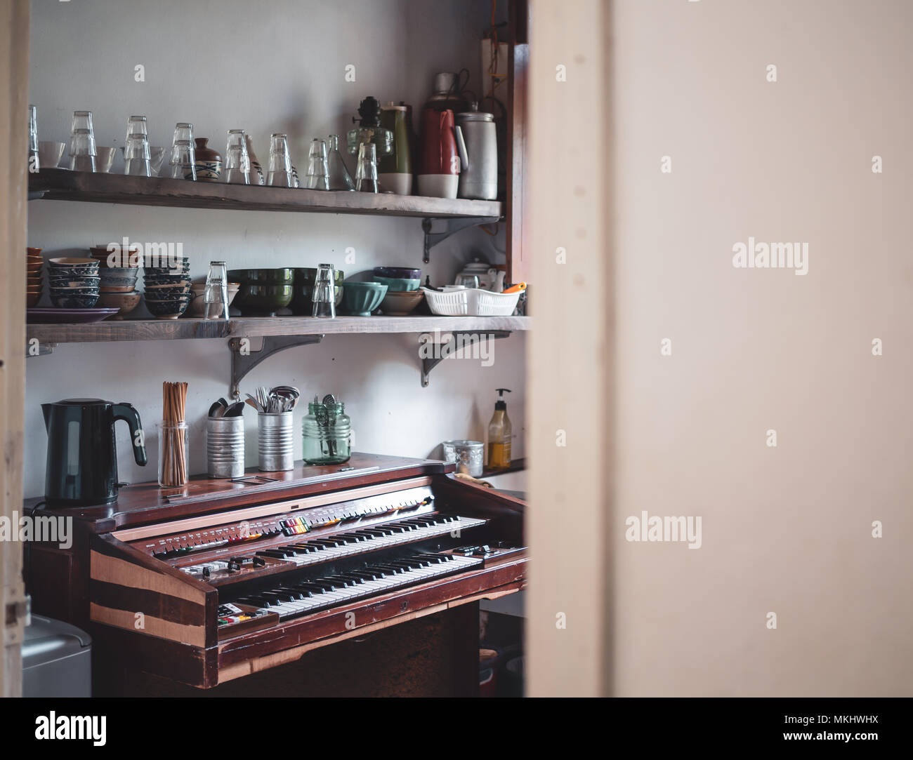 Kitchen Room, Inside with Vintage Electone Keyboard and Local Home Kitchenware, Glasses, Ceramic Cup, Spoons, Forks, Bowls on  Wooden Shelves Stock Photo