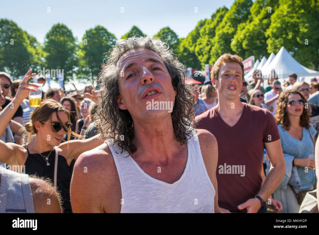 Middle aged man with long hair intensely enjoying music at liberation feast in the Netherlands Stock Photo