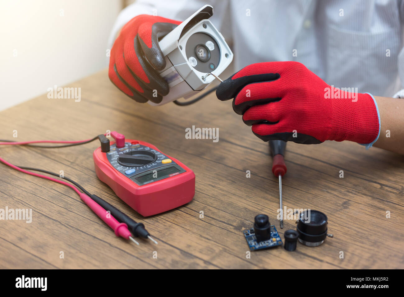 technician repairs CCTV camera on the table. Stock Photo
