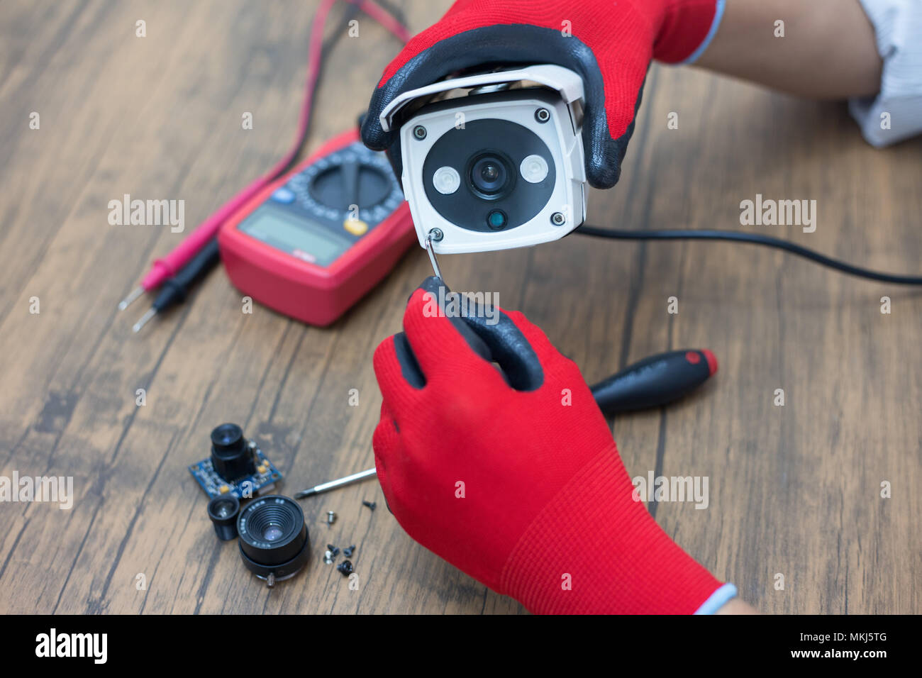 technician repairs CCTV camera on the table. Stock Photo