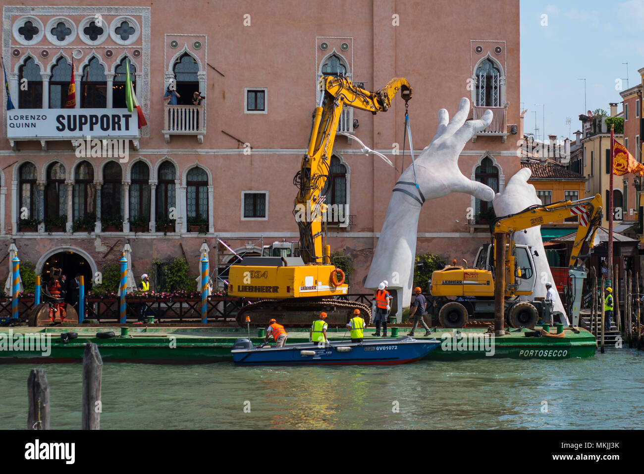 VENICE, ITALY. 08 MAY, 2018. One hand of the work of Lorenzo Quinn is disassembled and placed on a large barge for transport in Venice, Italy on 5 May 2018. The work of the artist Lorenzo Quinn 'Support', known as the 'big hands that support Venice', leave the Grand Canal to return to the artist's studio in Spain. © Simone Padovani / Awakening / Alamy Live News Stock Photo