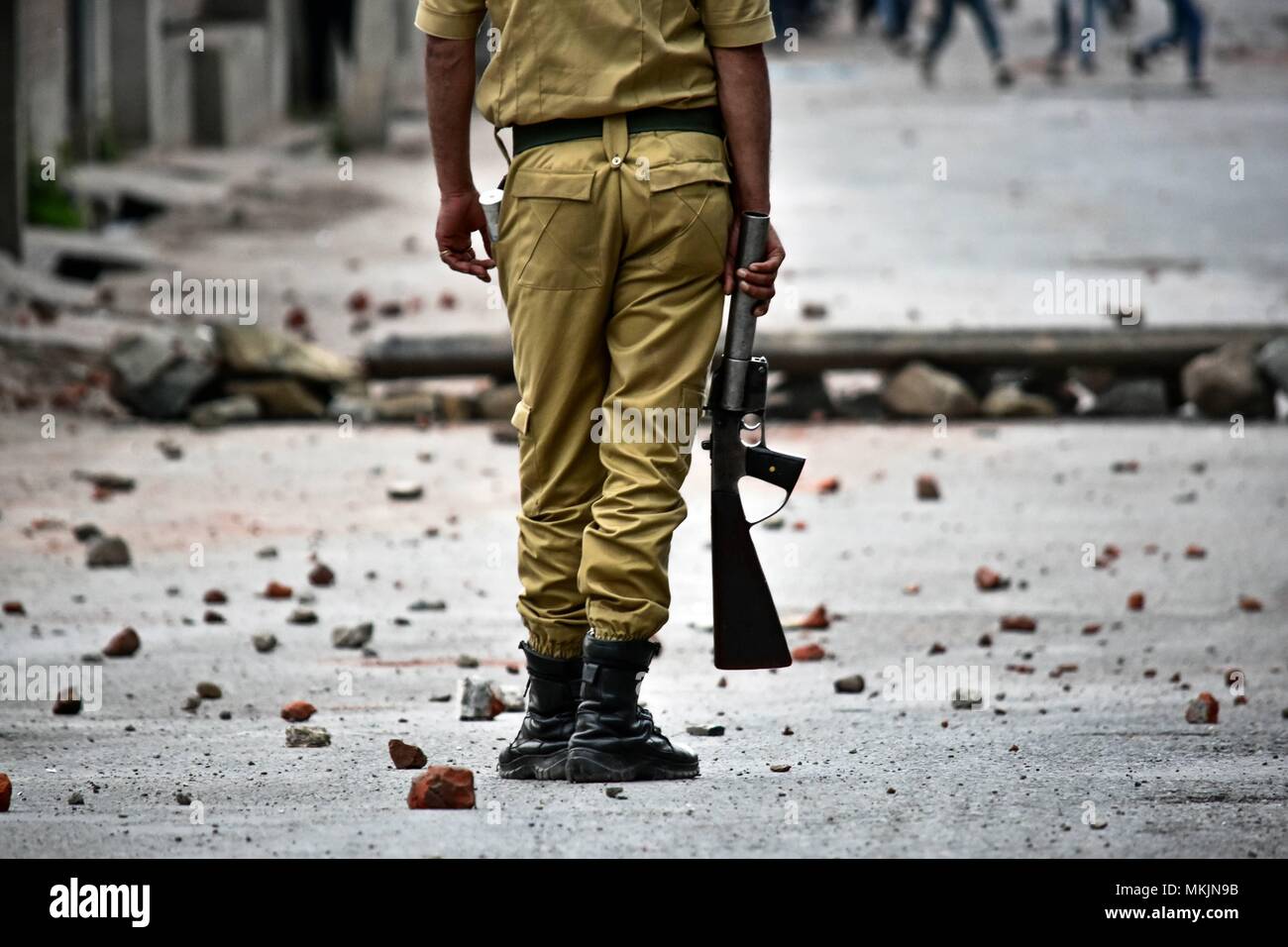 Srinagar, Kashmir. 8th May 2018. An policeman stands still during clashes in Srinagar, Kashmir. Fierce clashes broke out between government forces and Kashmiri protesters in Srinagar on Tuesday as the valley continued to remain tense over the killing of 11 people including 5 militants and 6 civilians in Kashmir. Police used tear smoke shells and shot gun pellets to disperse hundreds of demonstrators who hurled rocks and chanted anti-and pro-freedom slogans. Credit: SOPA Images Limited/Alamy Live News Stock Photo