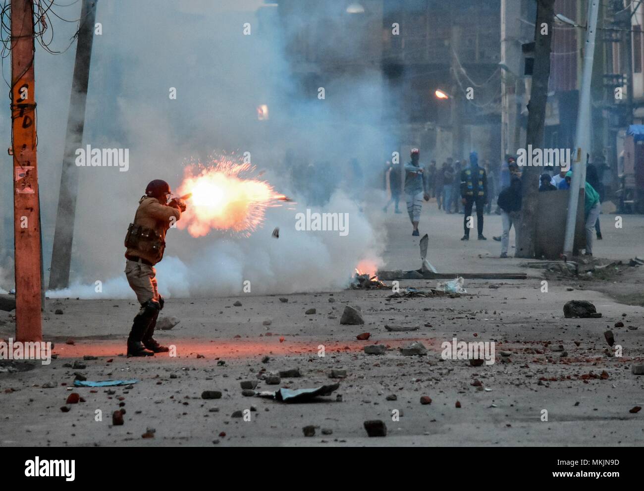 Srinagar, Kashmir. 8th May 2018. An policeman fire tear gas shell towards Kashmiri protesters during clashes in Srinagar, Kashmir. Fierce clashes broke out between government forces and Kashmiri protesters in Srinagar on Tuesday as the valley continued to remain tense over the killing of 11 people including 5 militants and 6 civilians in Kashmir. Police used tear smoke shells and shot gun pellets to disperse hundreds of demonstrators who hurled rocks and chanted anti-and pro-freedom slogans. Credit: SOPA Images Limited/Alamy Live News Stock Photo