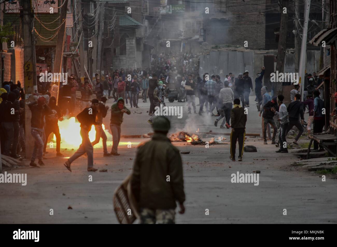 May 8, 2018 - Srinagar, J&K, India - A tear gas shell explodes near Kashmiri protesters during clashes in Srinagar, Indian administered Kashmir. Fierce clashes broke out between government forces and Kashmiri protesters in Srinagar on Tuesday as the valley continued to remain tense over the killing of 11 people including 5 militants and 6 civilians in Indian administered Kashmir. Police used tear smoke shells and shot gun pellets to disperse hundreds of demonstrators who hurled rocks and chanted anti-Indian and pro-freedom slogans. Credit: Saqib Majeed/SOPA Images/ZUMA Wire/Alamy Live News Stock Photo