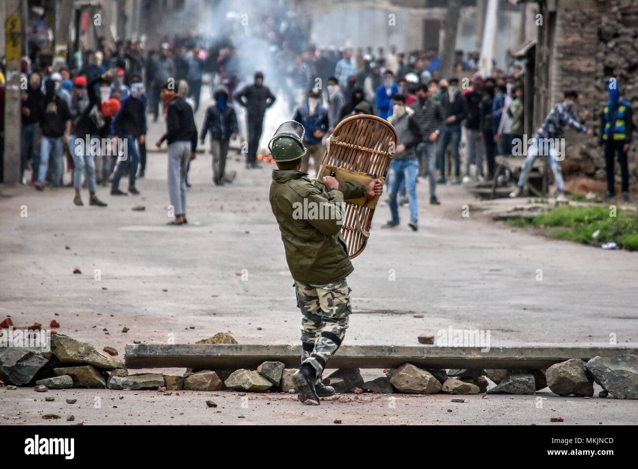 May 8, 2018 - Srinagar, J&K, India - An Indian paramilitary trooper shields himself from stones hurled by Kashmiri demonstrators during clashes in Srinagar, Indian administered Kashmir. Fierce clashes broke out between government forces and Kashmiri protesters in Srinagar on Tuesday as the valley continued to remain tense over the killing of 11 people including 5 militants and 6 civilians in Indian administered Kashmir. Police used tear smoke shells and shot gun pellets to disperse hundreds of demonstrators who hurled rocks and chanted anti-Indian and pro-freedom slogans. (Credit Image: © Saqi Stock Photo
