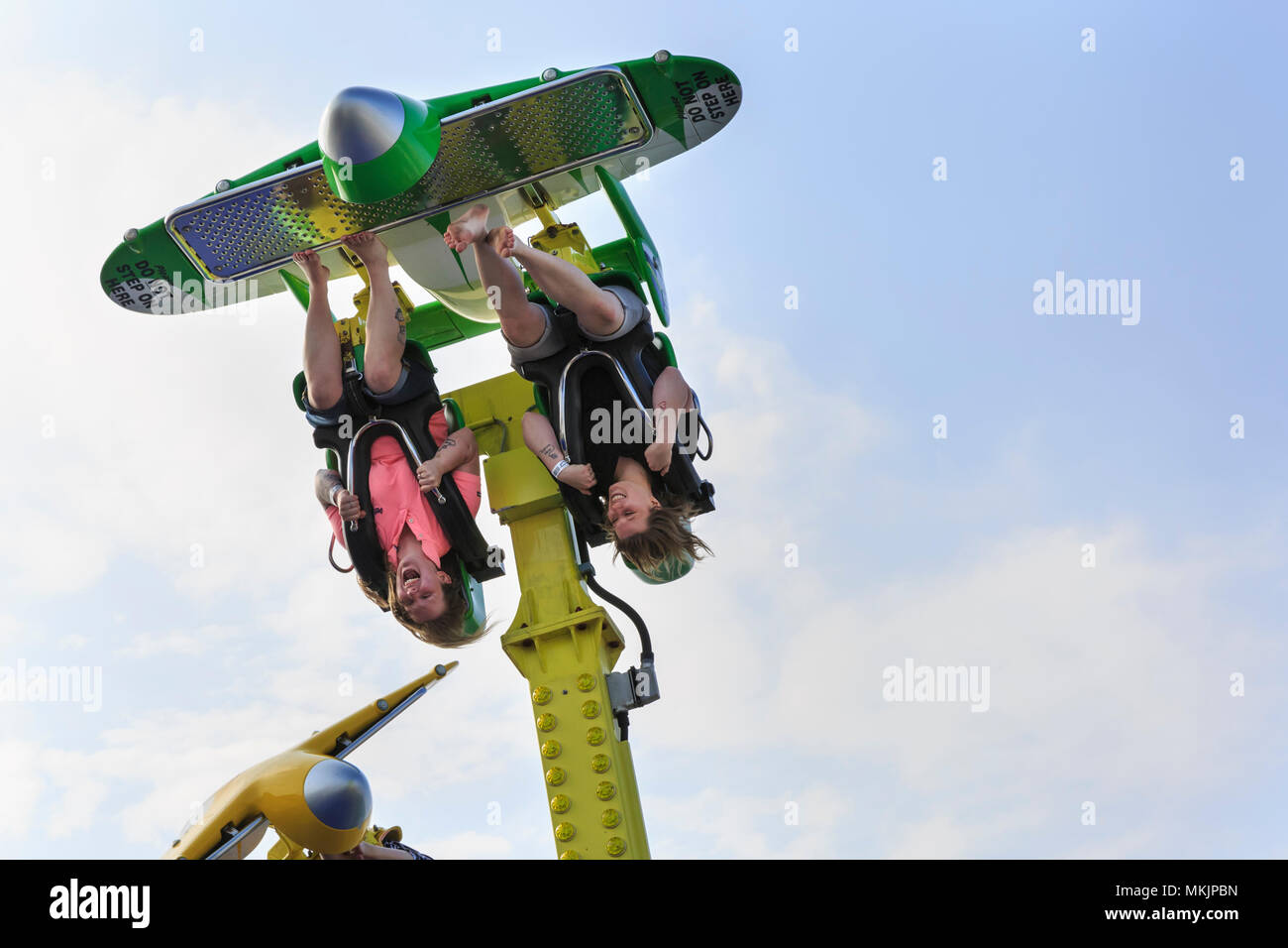 Brighton, East Sussex, 8th May 2018. Hanging in there! Two women clearly enjoy their funfair ride called 'Air Race', sitting in carriages looking like airplanes, on Brighton Pier. Another beautifully sunny and warm afternoon in the seaside town of Brighton in East Sussex may have been the last for a while, as the weather is forecast to turn cooler and cloudier in the coming days. Credit: Imageplotter News and Sports/Alamy Live News Stock Photo