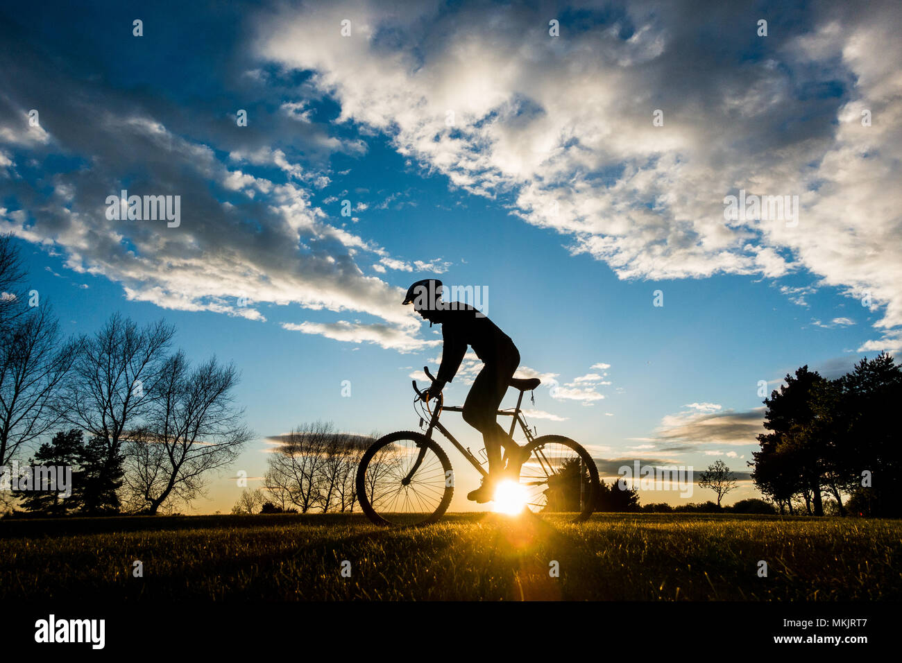 Mountain biker at sunset. UK Stock Photo
