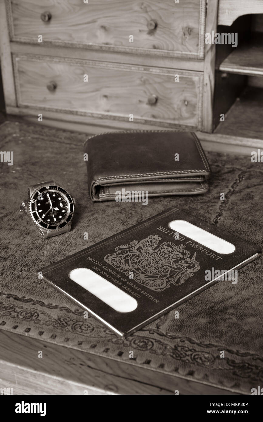 british passport, wallet and rolex watch on timber antique desk, with name blanked out Stock Photo
