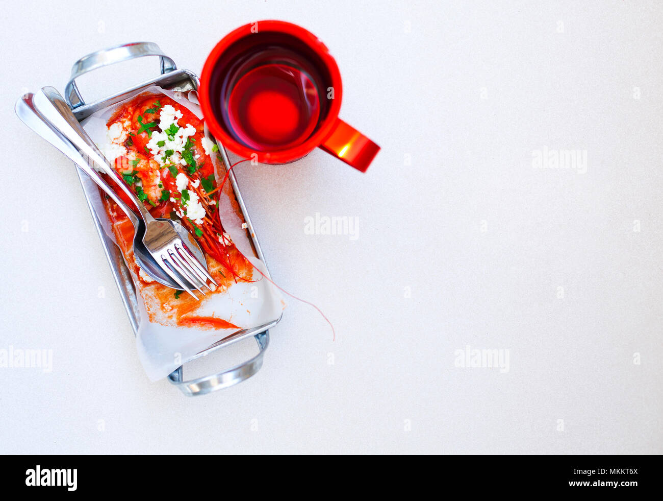 Greek starter shrimp in tomato sauce with cup of red wine. Top view Stock Photo