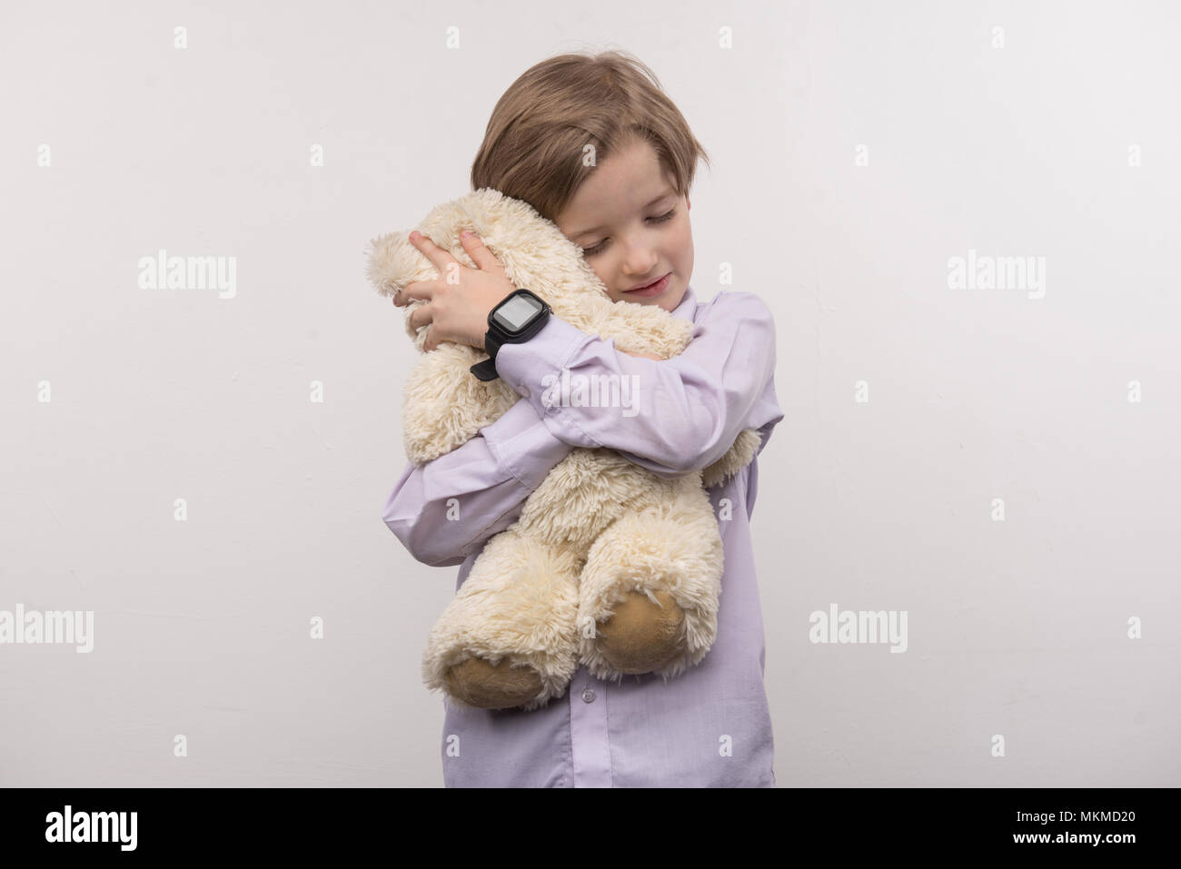 Delighted happy boy hugging his toy Stock Photo Alamy