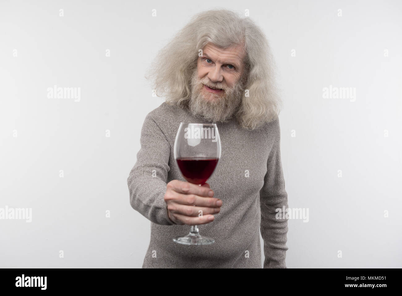 Positive aged man offering you wine Stock Photo - Alamy