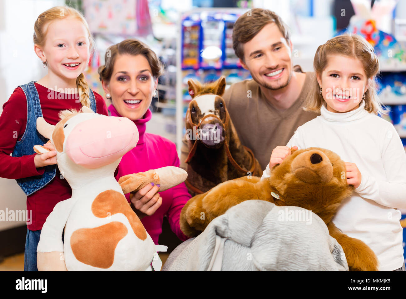 Family with stuffed elephant in toy store playing Stock Photo