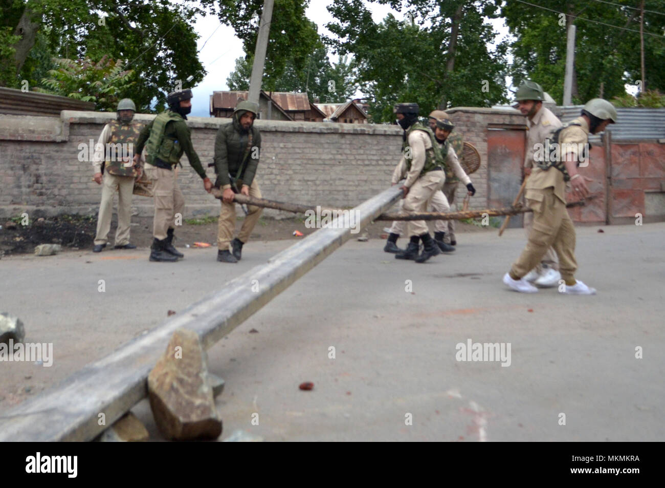 Srinagar, India. 07th May, 2018. Forces remove a road block as youth clash with Indian government forces in Srinagar, Indian Administered Kashmir on 07 may 2015. Hundreds of youth took to the streets and clashes with Government forces against the Killings of 5 Civilians and 5 rebels during a gunfight in Shopian district of the Valley on 06 May 2018. Meanwhile curfew had been put in place to thwart the protests. Credit: Muzamil Mattoo/Pacific Press/Alamy Live News Stock Photo