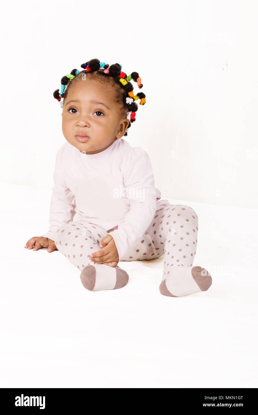 Portrait of nice baby sitting and looking at the camera on a white background Stock Photo