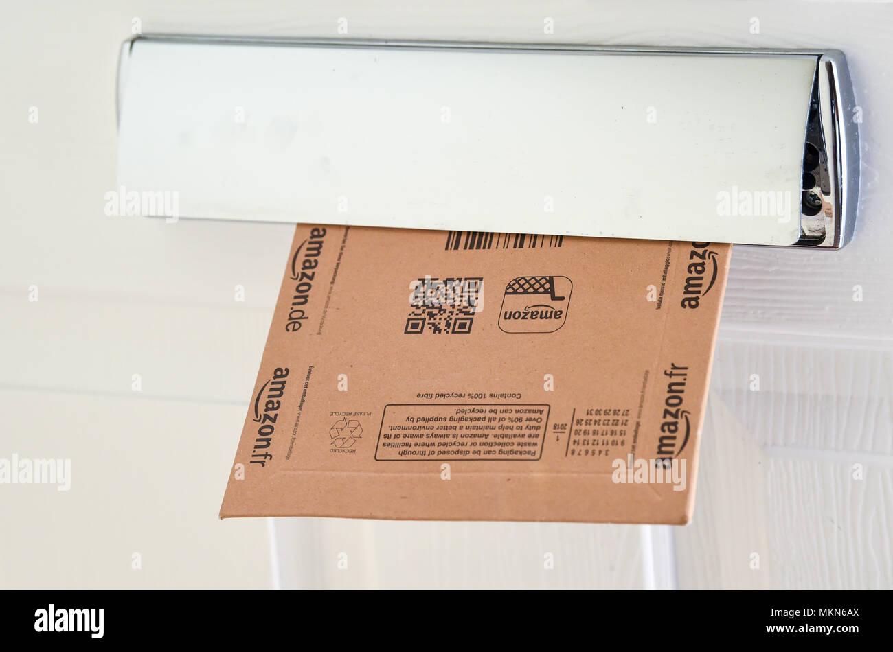 Amazon online shopping home delivery parcel in a household letter box  Photograph taken by Simon Dack Stock Photo