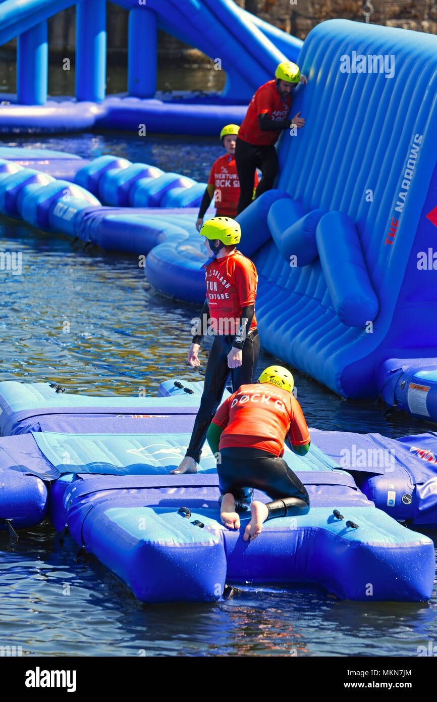 Children enjoying the Adventure Dock giant inflatable obstacle course in Dukes Dock Liverpool UK. Stock Photo