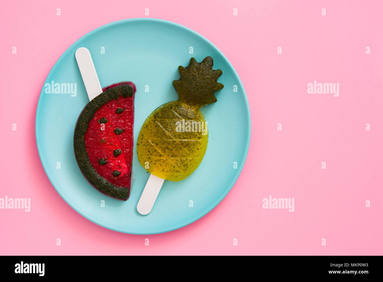 Pineapple and watermelon popsicles on pink background. Top view. Copyspace Stock Photo