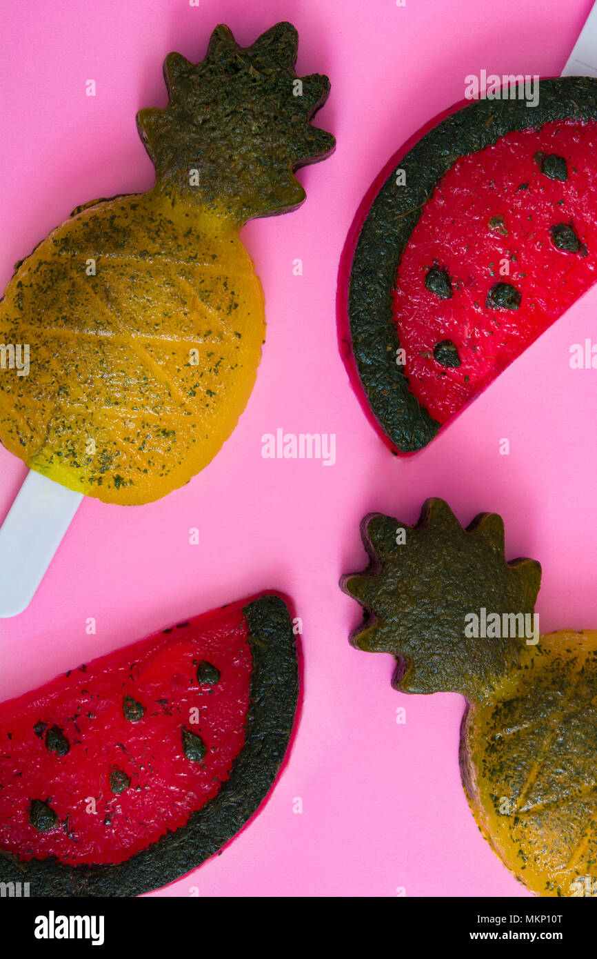 Pineapple and watermelon popsicles on pink background. Top view Stock Photo